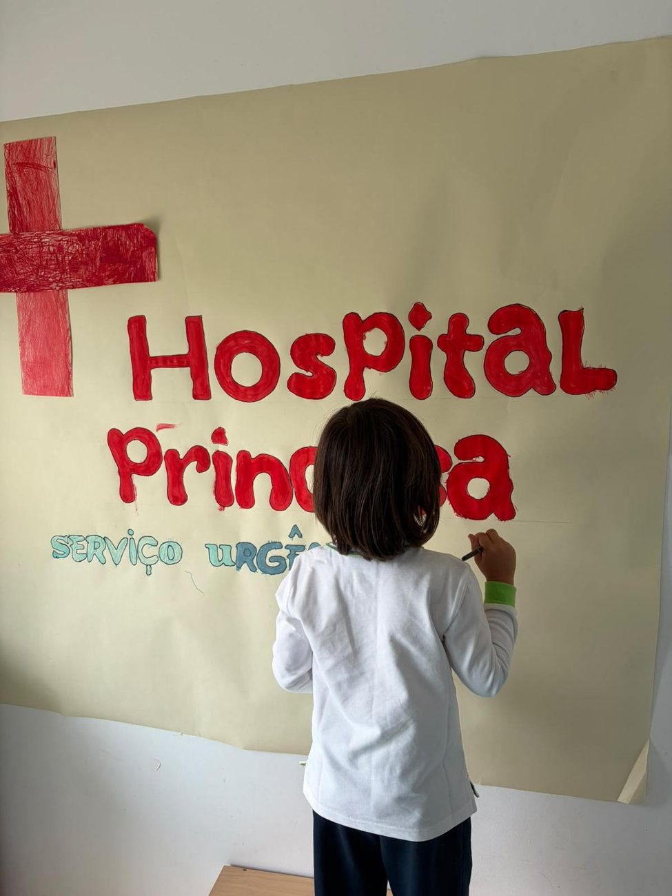 O hospital montado na sala, visto de trás, com as crianças a brincar